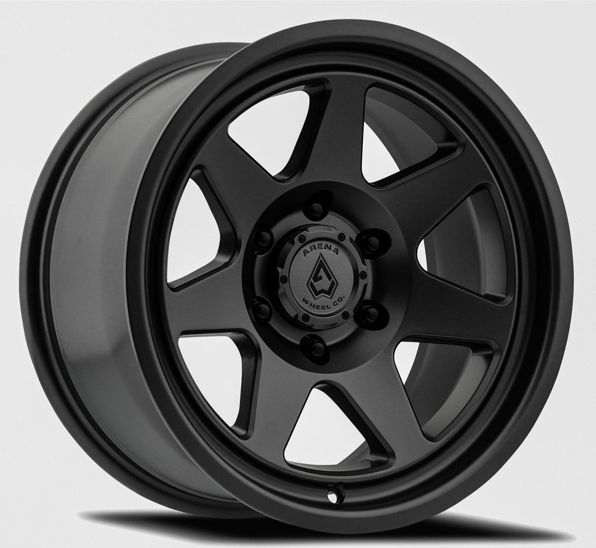 Black alloy wheel with a visible brand logo on a gray background