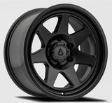 Black alloy wheel with a visible brand logo on a gray background