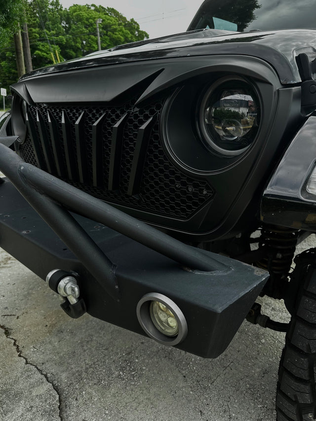 Close-up of a black off-road vehicle's front bumper and grille. Jeep Wrangler and Jeep Gladiator Front Grille.