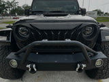 Front view of a black Jeep with additional lights and bumper on a road.